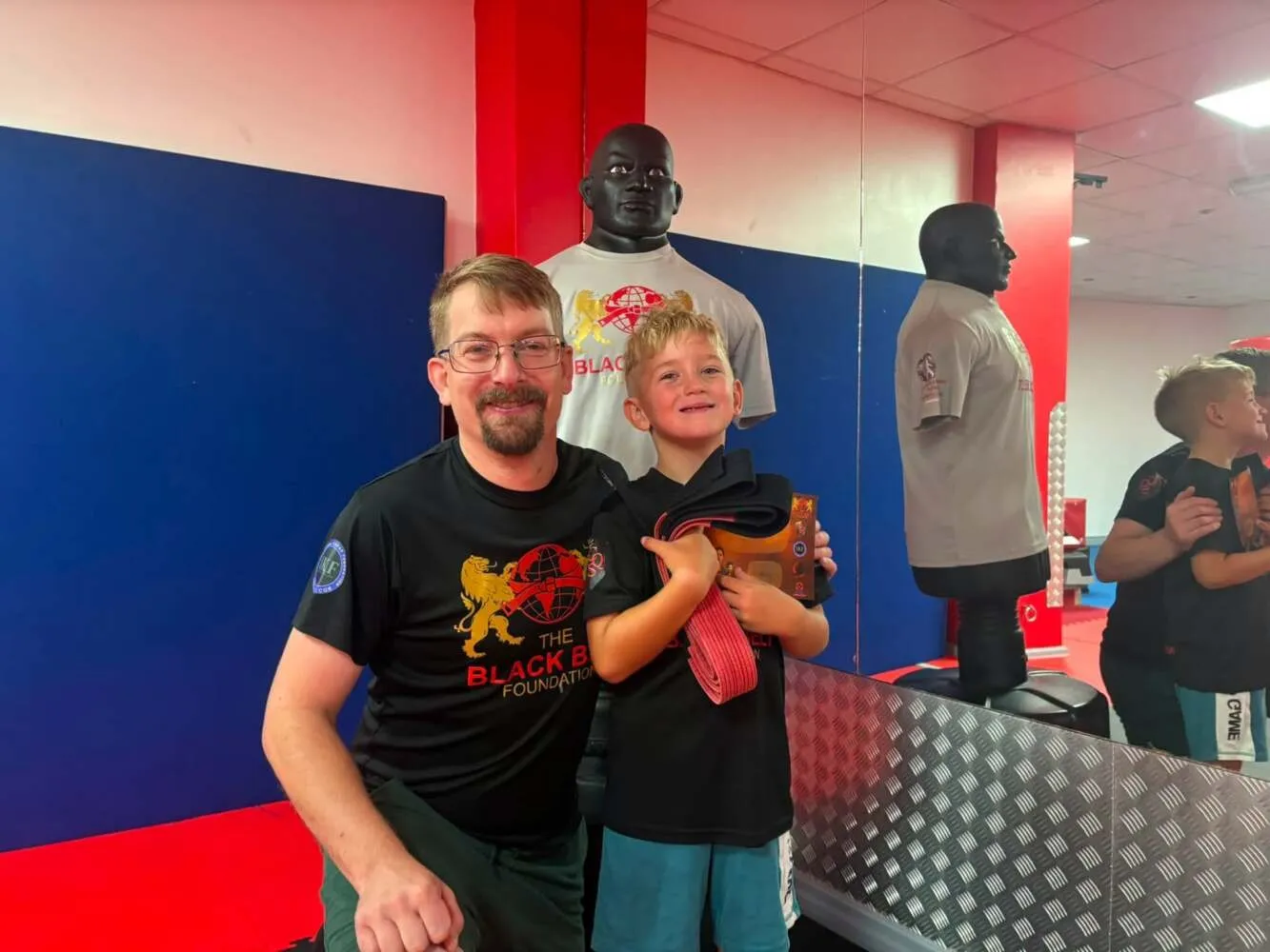 Instructor fist-bumping a junior student at The Black Belt Foundation academy in Chorley